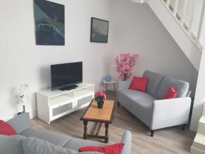 un soggiorno con 2 divani e una TV di Gardenia a Villenauxe-la-Grande