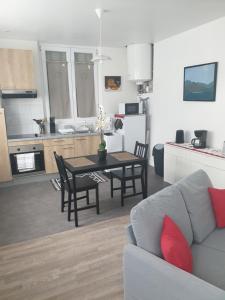 un soggiorno con divano e tavolo e una cucina di Gardenia a Villenauxe-la-Grande