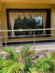 - un bâtiment doté d'une grande fenêtre avec des rideaux et des plantes dans l'établissement Saikat Saranya Resort, Mandarmoni Beach, à Mandarmoni