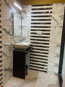 a bathroom with a sink and a wine bottle wall at Saikat Saranya Resort, Mandarmoni Beach in Mandarmoni