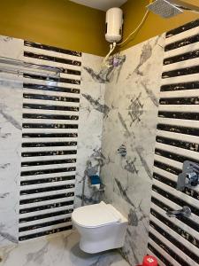 a bathroom with a toilet and a marble wall at Saikat Saranya Resort, Mandarmoni Beach in Mandarmoni