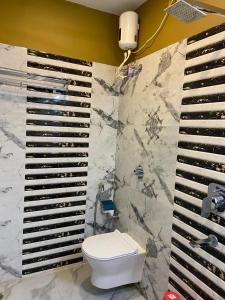 La salle de bains est pourvue de toilettes et d'un mur en marbre. dans l'établissement Saikat Saranya Resort, Mandarmoni Beach, à Mandarmoni