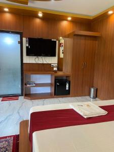 a bedroom with a bed and a flat screen tv at Saikat Saranya Resort, Mandarmoni Beach in Mandarmoni