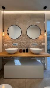 a bathroom with two sinks and two mirrors at Apartment Città di Mare in Cesenatico +17 photos