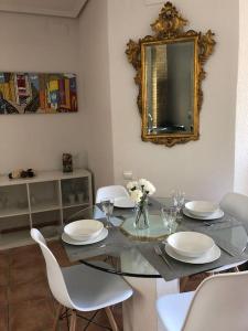 - une salle à manger avec une table en verre, des chaises et un miroir dans l'établissement Colón Market Downtown, à Valence