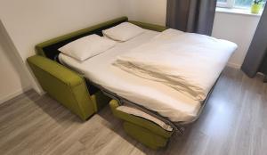 1 cama con marco verde y sábanas y almohadas blancas en Apart Hotel Roma, en Sofía