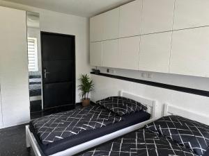 a bedroom with two beds and white cabinets and a plant at Ferienhaus Am Ettersberg in Ettersburg