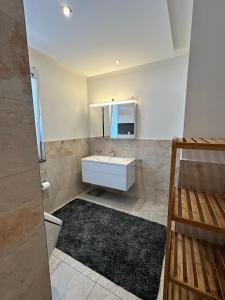 ein Badezimmer mit einem weißen Waschbecken und einem Spiegel in der Unterkunft Ferienhaus Am Ettersberg in Ettersburg