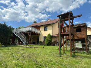 uma casa com um parque infantil de madeira no quintal em Ferienhaus Am Ettersberg em Ettersburg