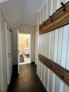 einen Flur mit Tür zu einem Bad mit Badewanne in der Unterkunft Ferienhaus Am Ettersberg in Ettersburg