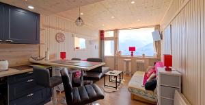 une cuisine et un salon avec une table et des chaises dans l'établissement Le Panorama D'Orcières, à Orcières