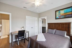 1 dormitorio con cama, escritorio y ventilador de techo en Cypress 85 1bedroom 1br With Pool Access!, en Tifton
