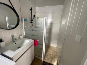 a white bathroom with a sink and a mirror at Petite maison à la mer in Sassetot-le-Mauconduit