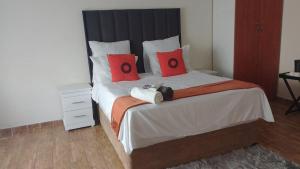 a bedroom with a large bed with red pillows at GOLDEN GLORY INN in Roodepoort