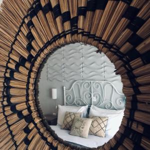 - un miroir reflétant un lit dans une chambre dans l'établissement Cozy flat with garden, à Tinos