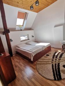 a bedroom with a bed and a rug and a window at Casa Sara in Săcele