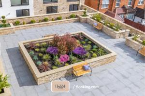 una vista sul giardino con panchine e fiori di Perfect For Contractors, Families, Business Stay, 2 Bed Apartment By HKM HOUSING Short Lets & Serviced Accommodation Cricklewood a Londra