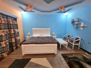 ein Schlafzimmer mit einem weißen Bett und einer blauen Wand in der Unterkunft Salsa Resort 