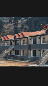 ein großes Gebäude mit einem roten Dach und einer Treppe in der Unterkunft Salsa Resort 
