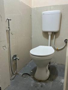 a bathroom with a white toilet in a stall at Avanti ONE 2BHK 3KM from Mahakal in Ujjain