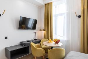 a room with a table and chairs and a tv at SQUARE APARTMENTS GDYNIA in Gdynia