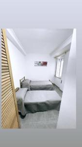 Habitación con 2 camas y sofá. en M&C Rooms di Claudia en Fiumicino