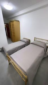 2 camas en una habitación con armario amarillo en M&C Rooms di Claudia en Fiumicino