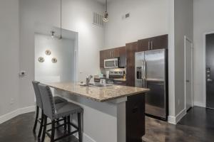 uma cozinha com um balcão com um lavatório e um frigorífico em Uptown 1br Apartment, Pool, Gym, Parking Cs em Dallas