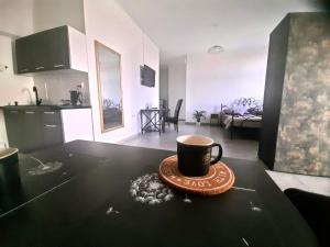a cup of coffee sitting on a table in a living room at Apartament For You Roztocze in Łabunie
