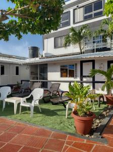 un patio con sillas y plantas frente a un edificio en EL GALY SU HOTEL FAMILIAR en San Andrés