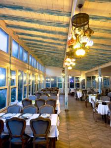ein Esszimmer mit weißen Tischen, Stühlen und Fenstern in der Unterkunft Fanizan Otel&Restaurant in Altınordu