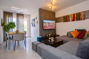 una sala de estar con un sofá y una mesa en Apartman Kiki, en Rabac