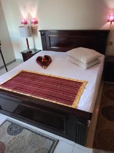 a bed with a wooden frame with a blanket on it at New Siesta Hotel & Resort in Alexandria