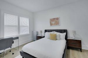 a bedroom with a white bed and a desk and window at Charming & Elegant 1bd1bth I Rochester in Rochester