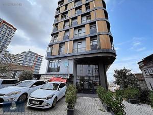 duży budynek z samochodami zaparkowanymi przed nim w obiekcie City center Luxurious residence w Stambule