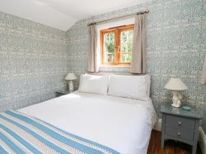 キャッスルトンにあるBee Garthのベッドルーム1室(青と白の壁紙のベッド1台付)