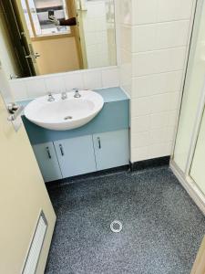 La salle de bains est pourvue d'un lavabo et d'un miroir. dans l'établissement Ausis Accommodation Services, à Melbourne