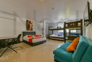 a bedroom with a couch and a bed and bunk beds at EL GALY SU HOTEL FAMILIAR in San Andrés