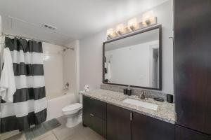 y baño con lavabo, aseo y espejo. en High End Apartment, Pool, Gym, Parking Cs, en Dallas