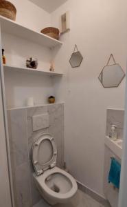een badkamer met een wit toilet in een kamer bij Cosy Flat - Stade de France in Saint-Denis