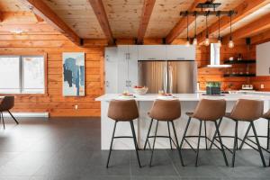 a kitchen with a large island with stools at Le Vertige - Ski Spa & Sauna in Saint Come