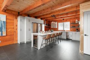 a kitchen with a counter and stools in a room at Le Vertige - Ski Spa & Sauna in Saint Come +58 photos