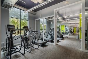 un gimnasio con cintas de correr, elípticas y bicicletas estáticas en High End Apartment, Pool, Gym, Parking Cs, en Dallas