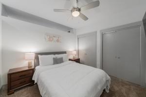 1 dormitorio blanco con 1 cama y ventilador de techo en Stunning 1 Bedroom Condo , Pool, Gym, Parking, Cs, en Dallas
