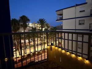 a balcony with a view of a street at night at Apartamento Tavernes Playa in Tavernes de Valldigna