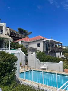 a swimming pool in front of a house at The Grosvenor Guest House & Self Catering in Simonʼs Town