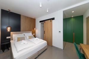 ein Schlafzimmer mit einem weißen Bett und einer grünen Wand in der Unterkunft White Rooms by Belmont Realty in Zadar