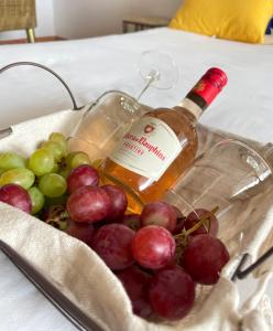 um cesto de uvas e uma garrafa de vinho em Lever du soleil em La Trinité