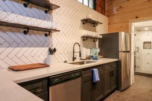 a kitchen with a sink and a refrigerator at Restored Historic Loft - 3 mins to the beach in Galveston