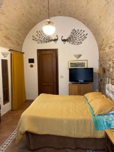 een slaapkamer met een bed en een flatscreen-tv bij L ORTENSIA in Lucera
